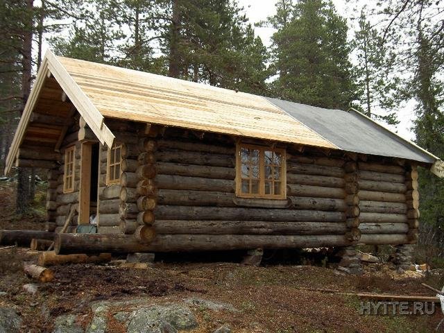 Sjarmerende tømmerhytte på 32 m2 med to soverom og et fremspringende tak som danner kalesje over inngangen